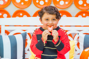 A happy child in costume enjoys a Nate's honey mini, surrounded by a lively, themed decor. A happy child in costume enjoys a Nate's honey mini, surrounded by a lively, themed decor.