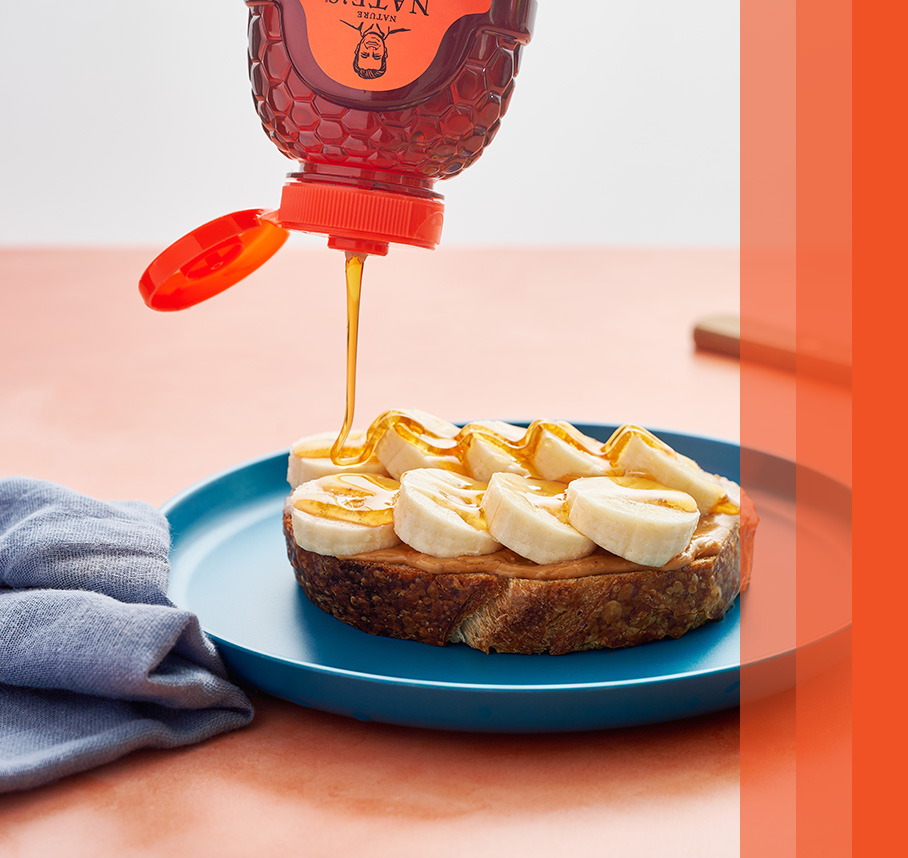Nate’s honey being drizzled on peanut butter and banana toast.