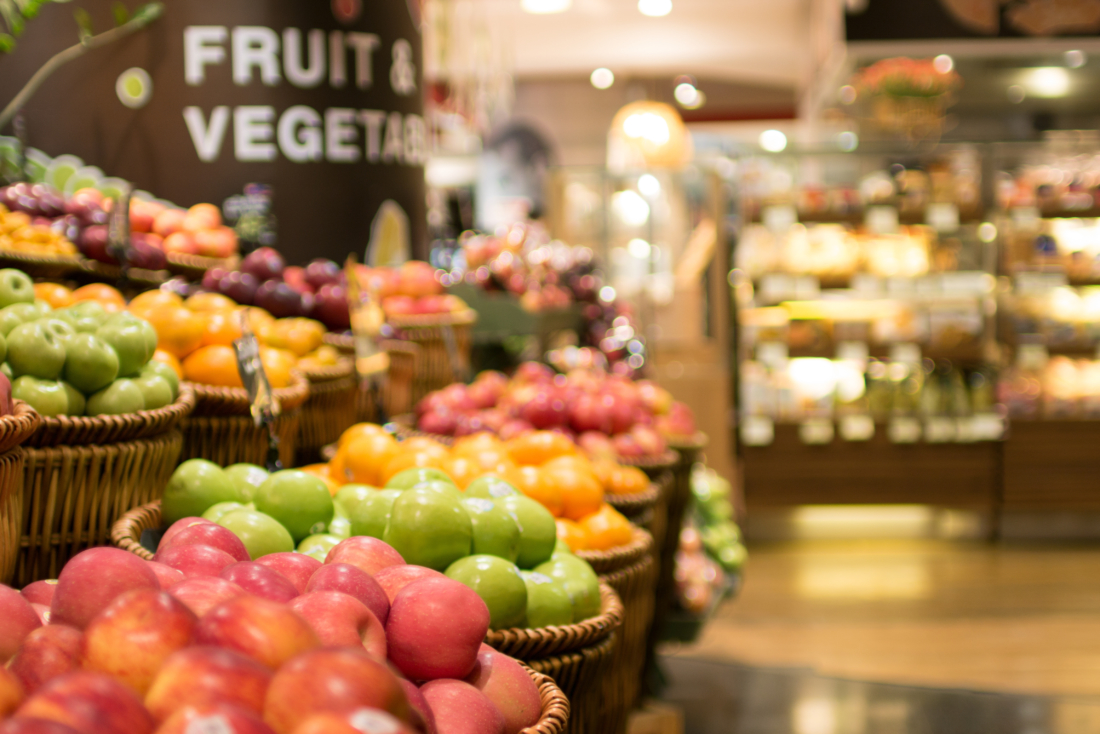 Colorful fruit display in a grocery store aisle.