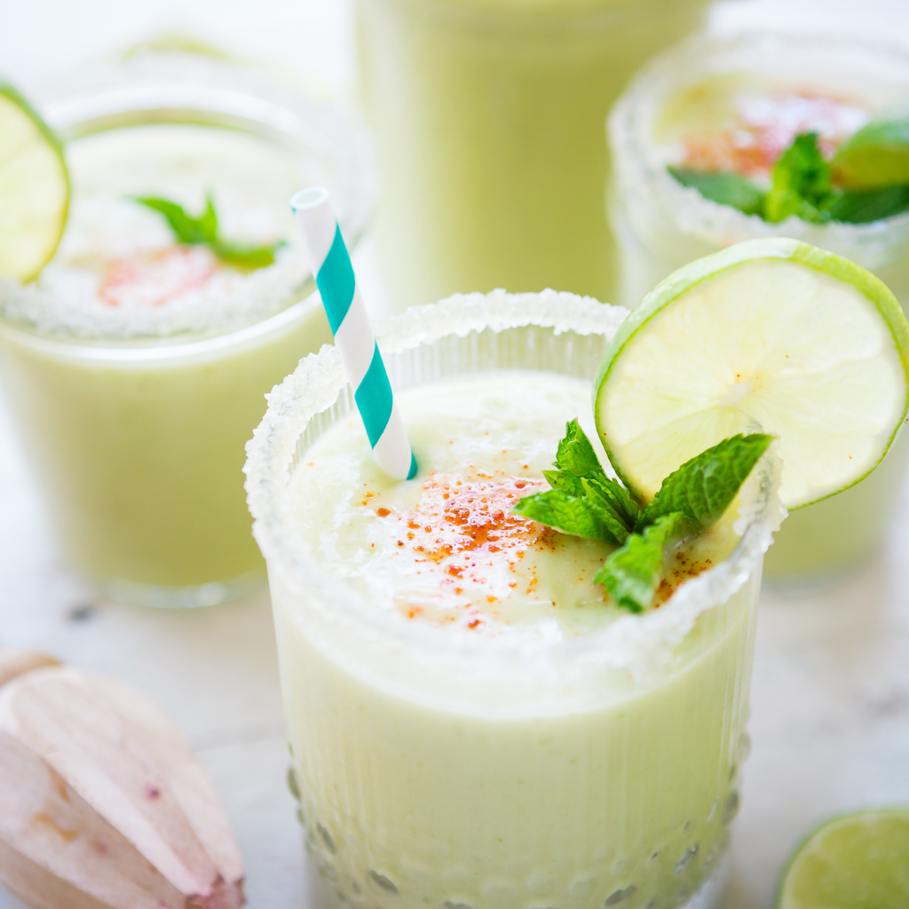 Frothy green smoothies with lime and mint, a bright, refreshing setting.