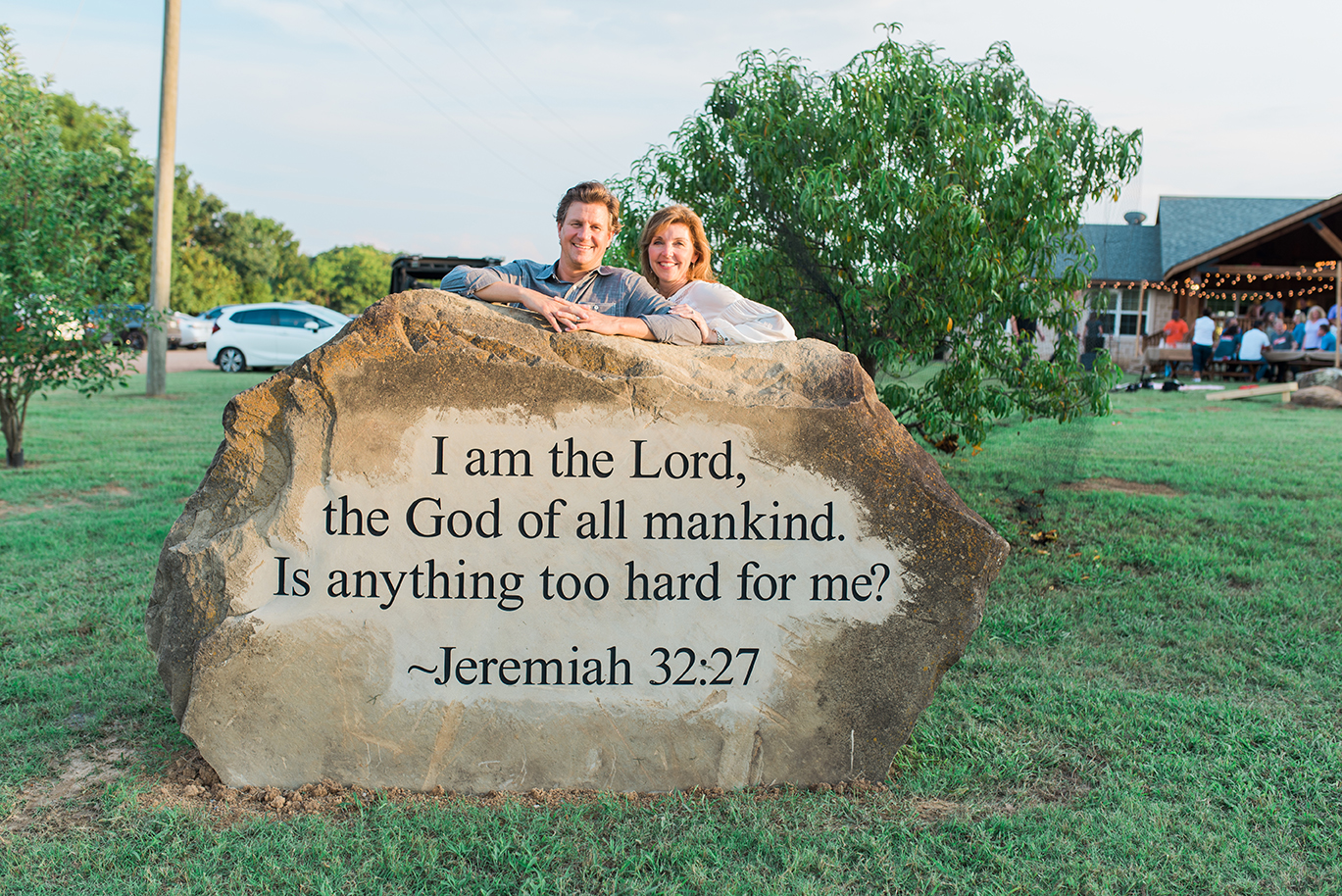  Two people behind a rock inscribed with a biblical verse_
I am the Lord, the God of all mankind. Is anything too hard for me?
  from Jeremiah 32:27.