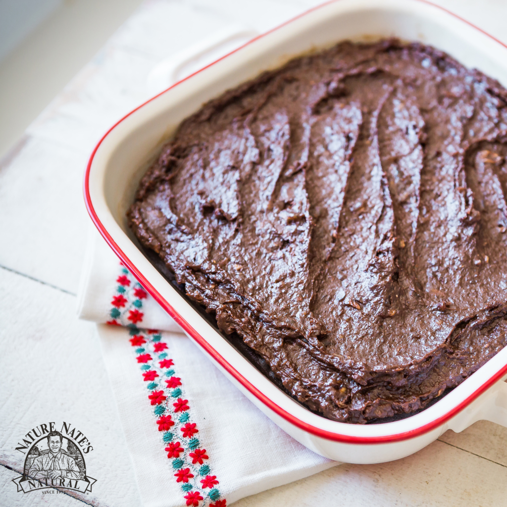 A pan of homemade brownies on a white napkin, next to a logo of Nature Nate’s Honey Co.