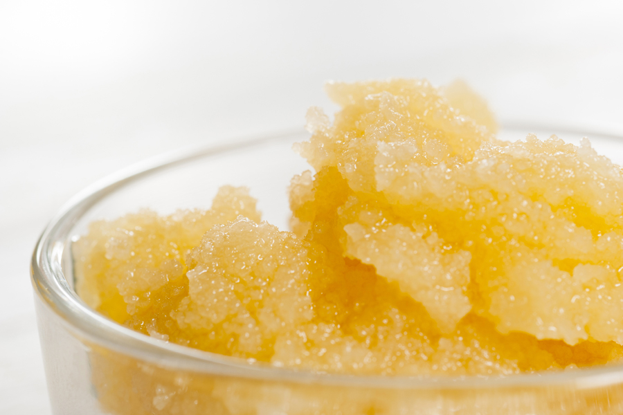 Golden granulated honey with a coarse, glistening texture.