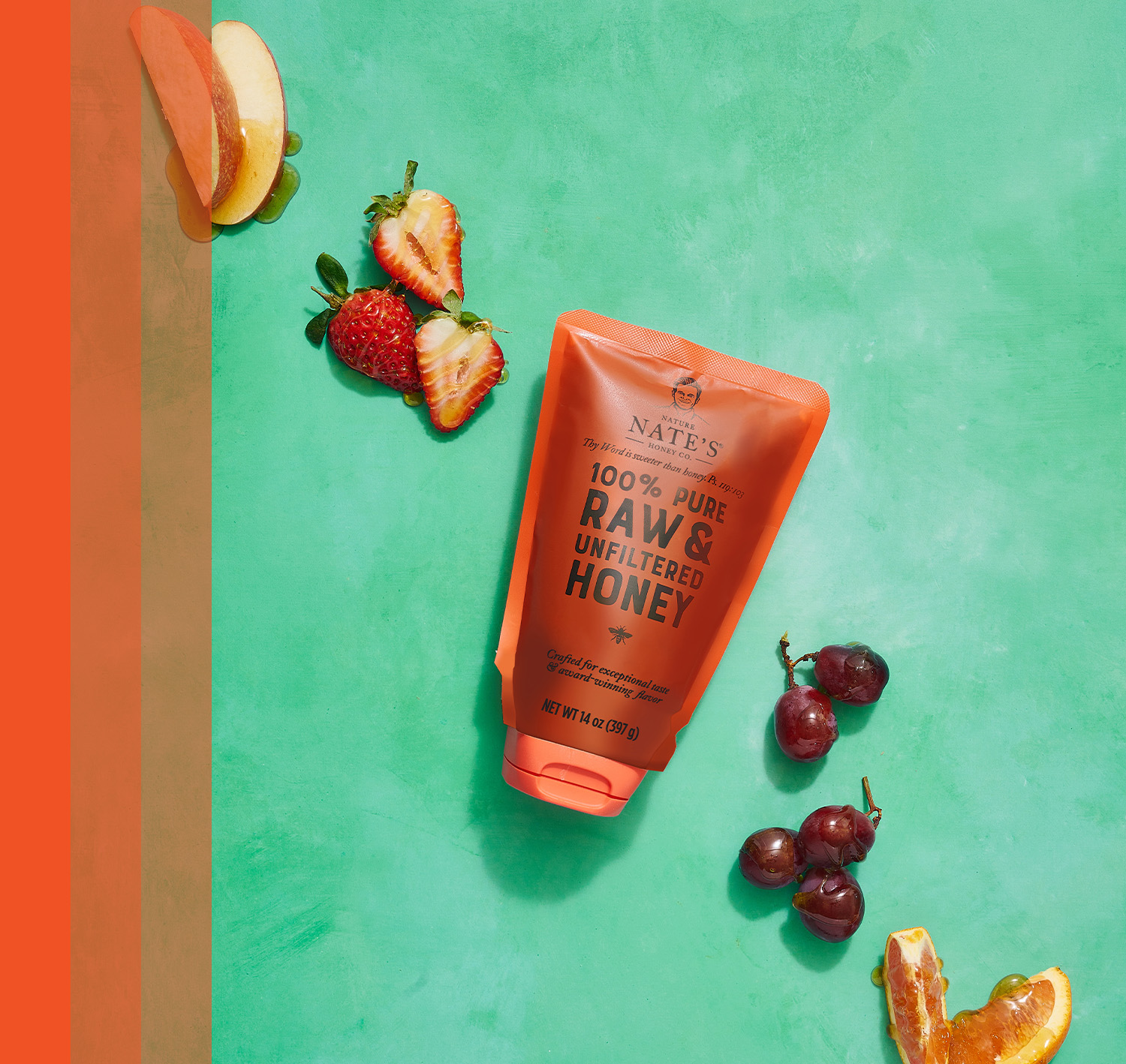 Nate's honey pouch with honey-drizzled fresh fruits on a green background.