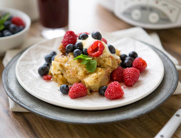 French toast topped with berries on a plate, with a radio in the background.