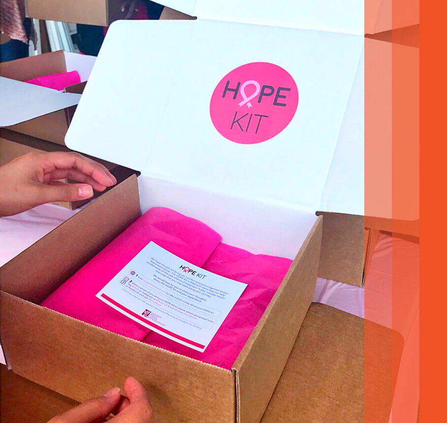 An open Hope Kit box for the National Breast Cancer Foundation with the "HOPE KIT" logo and pink tissue paper.