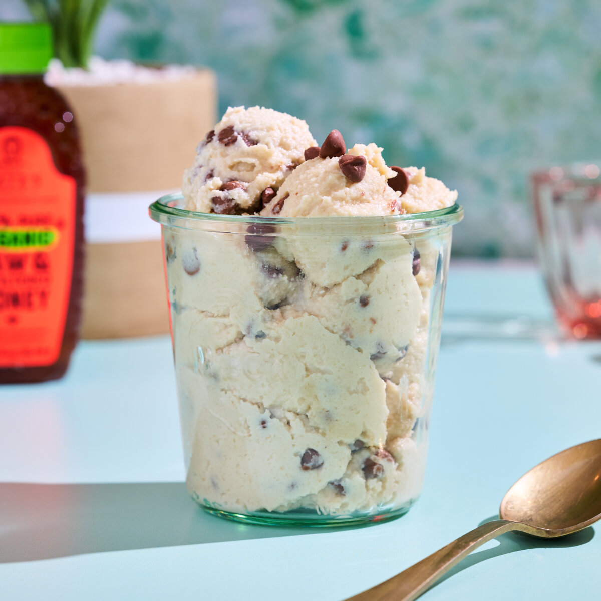 Cup of protein cookie dough with spoon next to it.