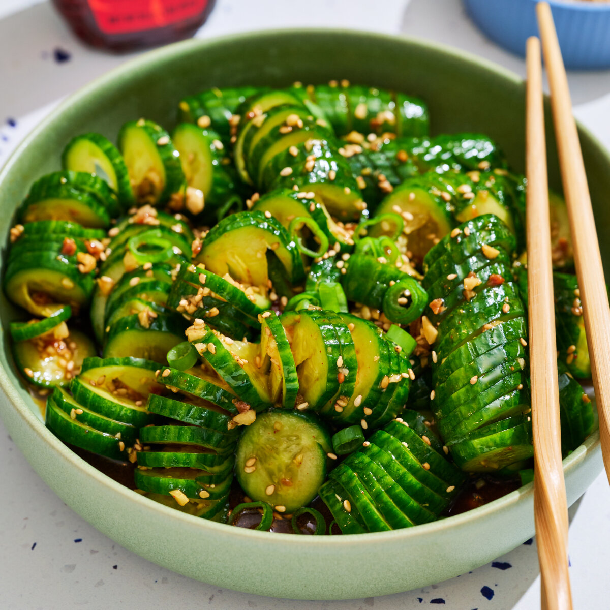 Cucumber salad spirals in green bowl.