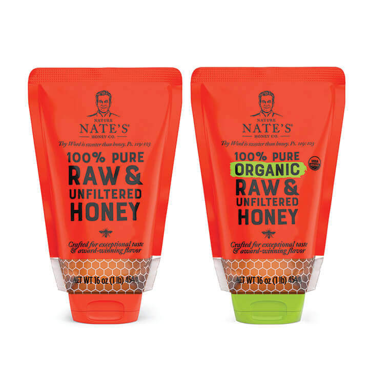 Two squeeze pouches of Nate’s honey, one original honey with orange cap and one organic honey with green cap.