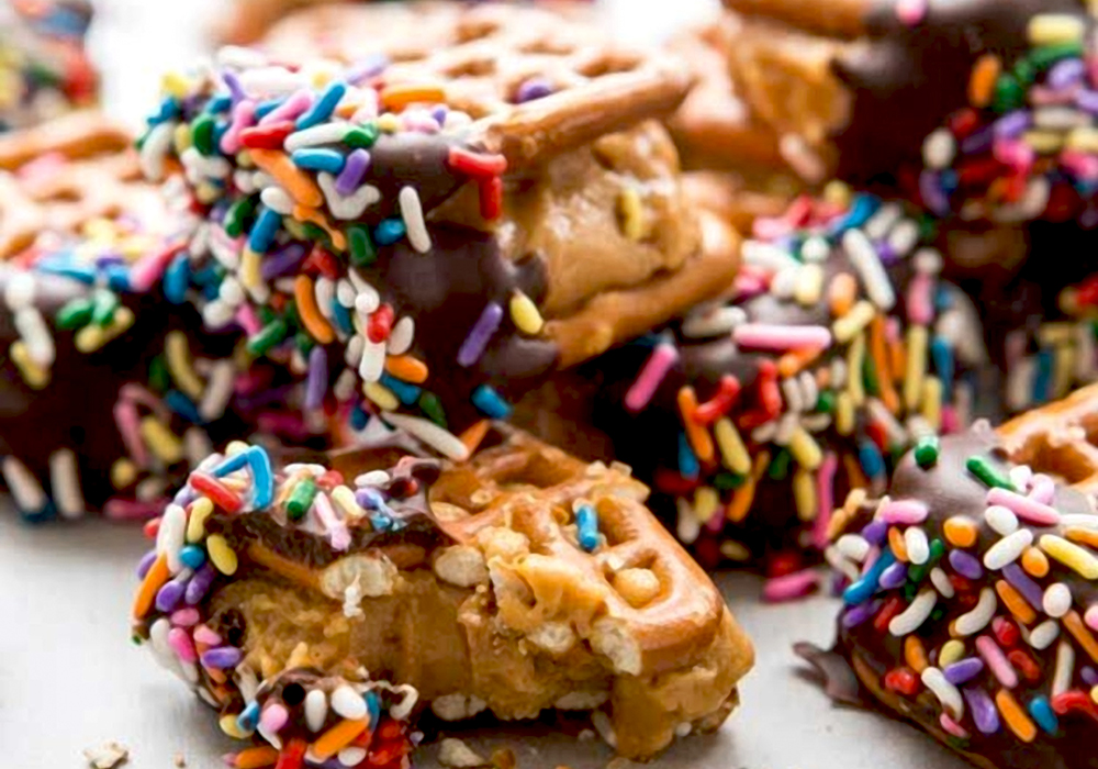 Chocolate-dipped waffle pretzels with colorful sprinkles on top.