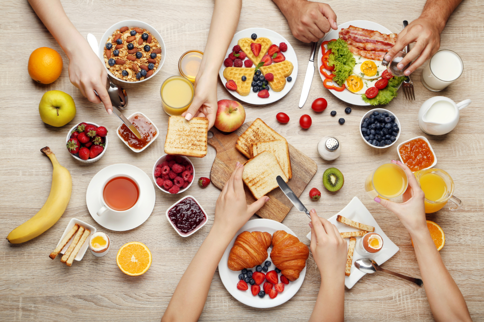 A family breakfast with an assortment of fruits, toast, and drinks.